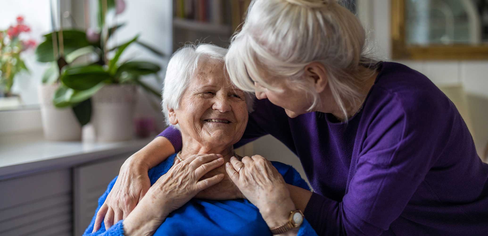 Supportive interaction between a caregiver and tenant in memory care at Meadowview of Clive.